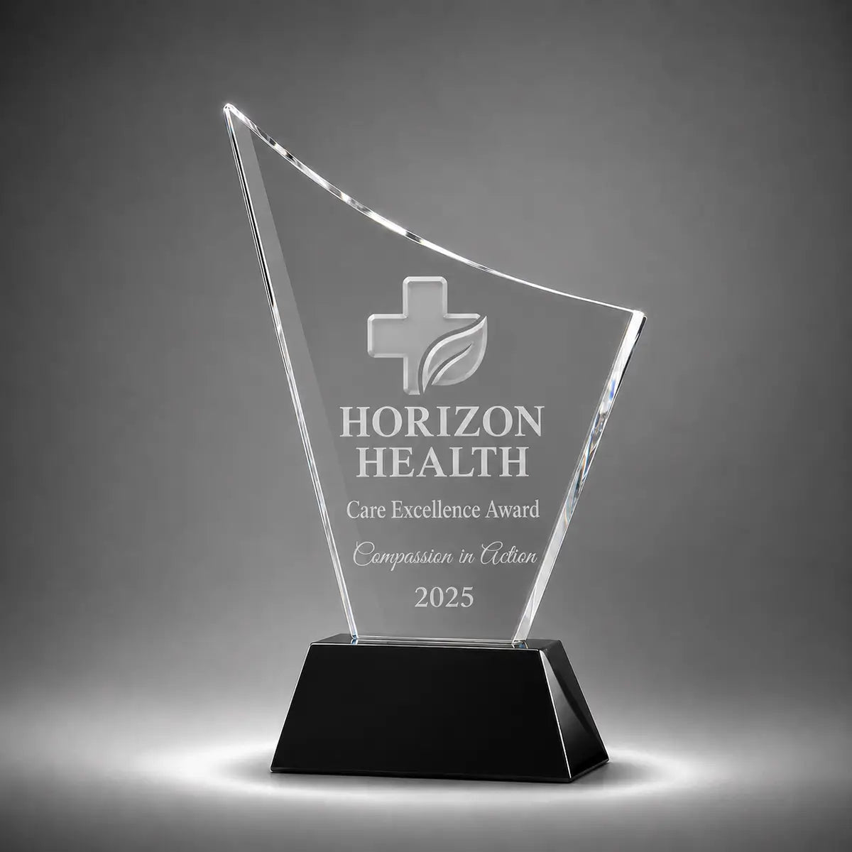 Custom curved crystal care excellence award trophy with personalised engraving, clear glass plaque and black base for healthcare recognition, nursing awards and medical staff appreciation.