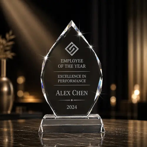Employee recognition crystal award with employee of the year engraving displayed under elegant spotlight lighting