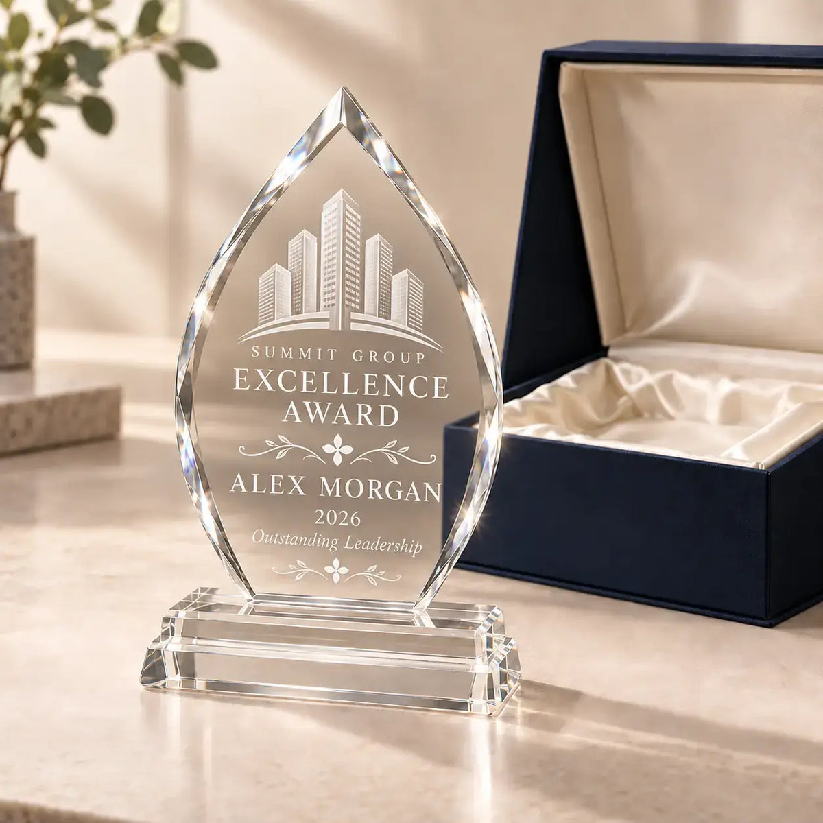 Arrowhead crystal award with a detailed building logo, floral dividers and Alex Morgan’s 2026 Excellence Award inscription beside a luxury gift box