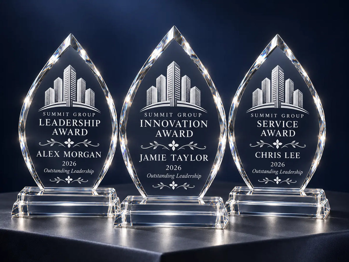 Three arrowhead crystal awards with matching company logos and individual recipient names and award titles